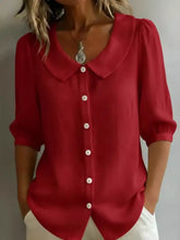 A vibrant red lightweight plus size button-down blouse with a classic peter pan collar and three-quarter sleeves