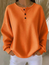 Bright orange full size waffle knit henley top with black buttons machine wash cold for easy care