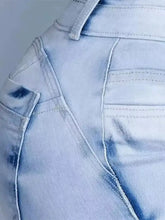 Light-wash denim high-waisted flare jeans with subtle fading and classic stitched pocket design for plus size