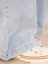 Light-wash denim full size wash wide leg cargo jeans with faded soft texture and neatly rolled cuffs in plus size