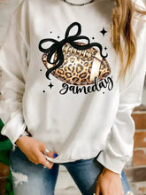 White crew neck sweatshirt with leopard rugby graphic football tied with black bow and gameday cursive script design