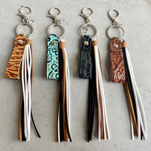 Four genuine leather tassel keychains with embossed straps and colorful tassels