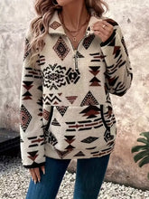 Cream-colored fleece half zip long sleeve sweatshirt with geometric tribal pattern in black and rust brown, machine wash cold