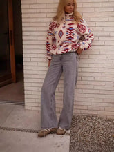 A cozy cream-colored fleece sweatshirt with a bold red blue and white geometric pattern machine wash cold