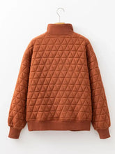 A cozy rust-colored geometric quilted half zipped loose sweatshirt with a high collar and machine wash care instructions