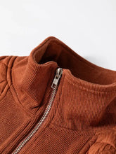 A rust-colored corduroy geometric quilted half zipped loose sweatshirt with ribbed texture and machine wash care instructions