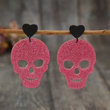 Glittery pink acrylic skeleton heart earrings with black studs