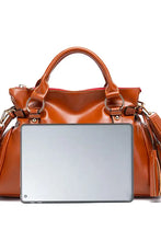 Shiny PU leather handbag with tassels and tablet display