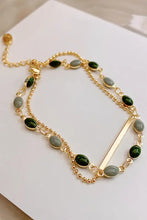 Gold alloy double layered bracelet with green and grey beads and rectangular bar detail
