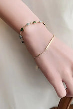 Elegant gold alloy double layered bracelet with green and grey beads on womans arm