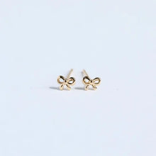 Delicate gold bow stud earrings with pearl drop in copper design