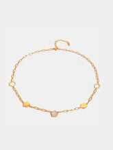 Gold necklace with flower charms, pink stone, and mother-of-pearl inlay