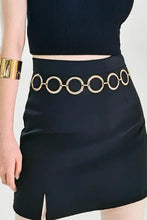 Black mini skirt with side slit and gold circle ring chain belt