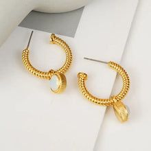 Gold twisted hoop earrings with cat’s eye stone charms and opal accents