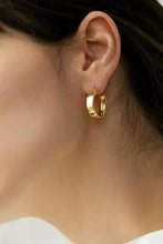 Gold-plated brass huggie earrings with thick hoop on ear