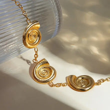 Gold spiral charm necklace with snail shell pendants