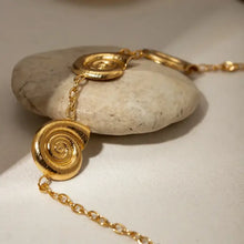 Gold spiral charm necklace with textured snail shell pendants