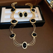 Gold-tone oval gemstone necklace and earrings set with triple-strand chains