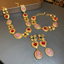 Gold toned copper inlaid rhinestone necklace and bracelet set with pink heart and floral accents