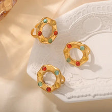 Three gold-toned titanium steel glass bead rings with colorful gemstones
