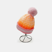 Gradient knit hat with fluffy pink pom-pom in orange and pink