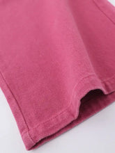 Close-up of pink gradient denim in Gradient Wide Leg Overalls, worn texture