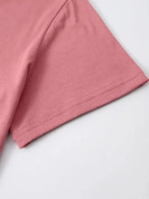 Close-up of pink graphic round neck short sleeve t-shirt with double-stitched hem