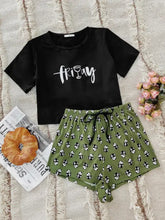 Black short-sleeved crop top with white cursive friday text and wine glass graphic in graphic tee and panda print shorts set