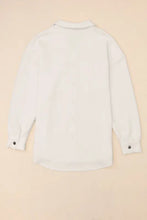 White linen button-down shirt with black buttons, cuffs, and sleeve length options