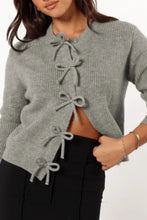Gray lace-up cardigan sweater with ribbed cuffs and black pants