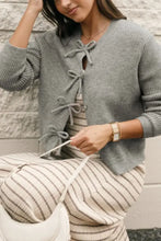 Gray lace-up cardigan sweater with ribbed cuffs and button details