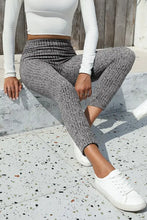 Gray ribbed knit jogger pants in high waist hip hugging full length fit with white crop top and sneakers