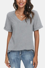 Woman in gray V-neck short sleeve T-shirt with regular sleeve length and rolled cuffs