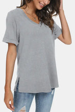 Woman in gray V-neck T-shirt with regular sleeve length and rolled cuffs