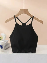Black ribbed grecian neck cropped tank with chest pads showing crisscross back straps on wooden hanger
