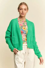 Green drop shoulder cardigan with relaxed fit, floral blouse, white pants