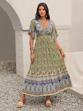 Woman in green floral maxi dress with printed flounce sleeve