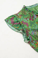 Green floral print ruffled shorts with sheer overlay and woven bag