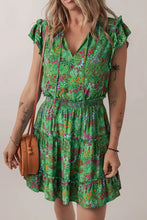 Green floral print tiered dress with ruffled sleeves and woven bag