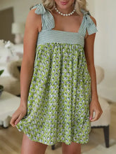 Green floral summer dress with ruffled shoulders and pearl necklace
