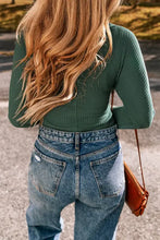 Womans green waffle knit wrap top with blue jeans