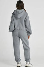 Grey oversized hoodie and jogger set in full length with white sneakers