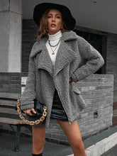 Gray teddy bear coat with fur texture, oversized pockets, high collar, and chain shoulder detail