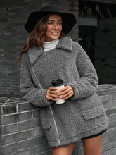 Grey teddy bear coat with fur texture, pockets, zipper, and chain shoulder detail