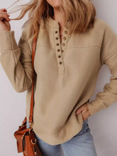 Beige long-sleeved grommet detail v neck sweatshirt with buttoned front and ribbed cuffs machine wash cold care instructions