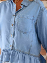 Light blue chambray half sleeve button down shirt with chest pocket and ruffled high low hem detail
