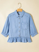 Light blue chambray shirt with collar button-front closure and ruffled high low hem half sleeve button down style