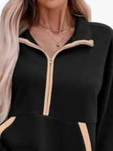 Black half zip dropped shoulder sweatshirt with beige trim along zipper and pockets machine wash recommended