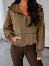 A cozy olive green half zip kangaroo pocket hoodie with mineral wash finish and ribbed cuffs in baggy style