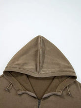 A tan mineral wash baggy hoodie with a half zip, kangaroo pocket, ribbed hem, and drawstrings